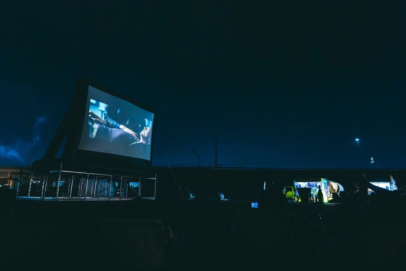 夜の会場に浮かぶ大型スクリーン。遠景。